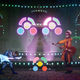 The Artful Escape's protagonist and another character, both wielding guitars, with colorful button prompts onscreen.